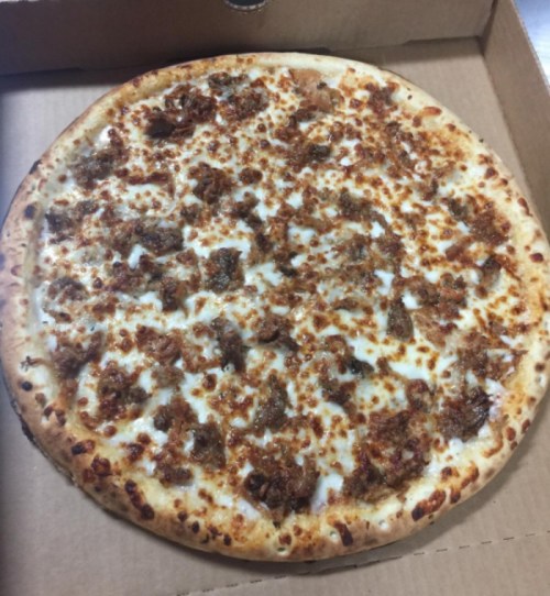 A freshly baked pizza with a golden crust, topped with melted cheese and chunks of meat.