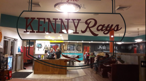 A view through a window of Kenny Rays restaurant, showing diners and a cozy interior with colorful decor.