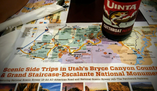 A map of Utah's Bryce Canyon and Grand Staircase-Escalante with a Uinta Cutthroat Pale Ale bottle nearby.