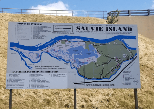 Map of Sauvie Island showing points of interest and a business directory, with a green landscape in the background.