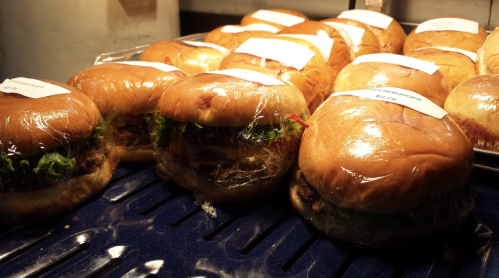 A display of wrapped burgers with lettuce, arranged neatly on a tray.