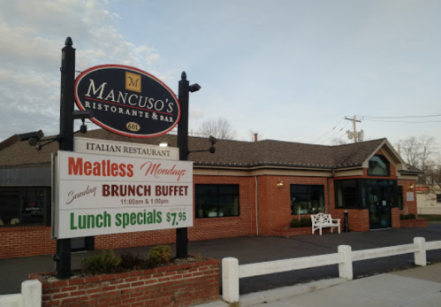 Sign for Mancuso's Italian Restaurant & Bar, featuring a brunch buffet and lunch specials. Brick building exterior.