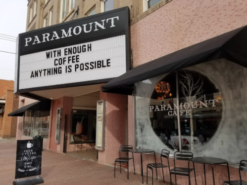 The Paramount Café features a marquee sign and outdoor seating, promoting coffee with the message, "With enough coffee, anything is possible."