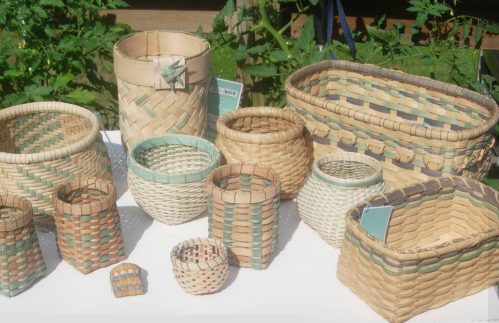 A variety of woven baskets in different shapes and sizes, featuring colorful patterns, displayed on a table.