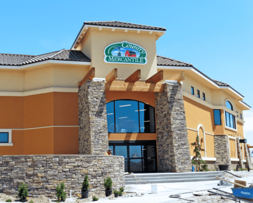 Exterior of County Mercantile building with stone accents and a clear blue sky in the background.