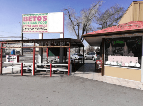 A Mexican restaurant with outdoor seating and a colorful storefront, featuring a sign that reads "Beto's Mexican Food."
