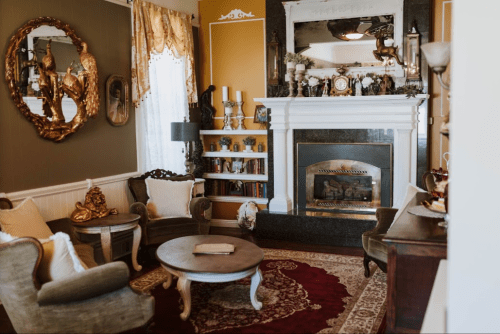 Cozy living room with a fireplace, elegant furniture, and decorative accents in warm tones.