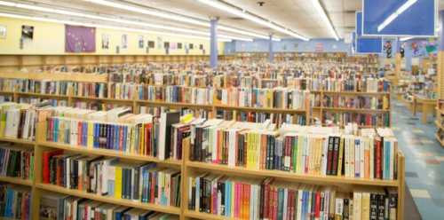 A spacious library filled with rows of bookshelves, showcasing a vast collection of books.