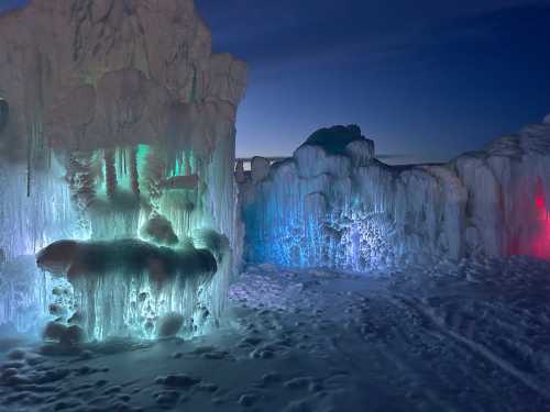 Illuminated ice formations in various colors, creating a magical winter landscape at dusk.