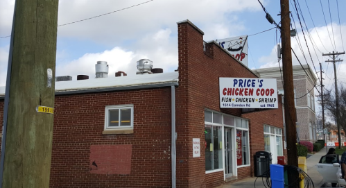 A brick building with a sign reading "Price's Chicken Coop" featuring fish, chicken, and shrimp, located on Camden Rd.