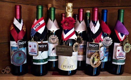 A collection of wine bottles with medals and ribbons, showcasing various awards and recognitions.