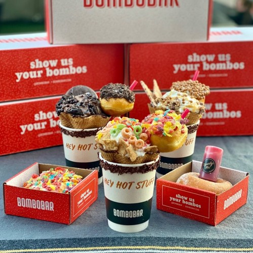 A colorful assortment of dessert cones and boxes from Bombobar, featuring donuts, cereal, and toppings.