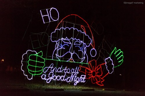 A colorful light display featuring Santa Claus holding a sign that says, "And to all a Good Night."