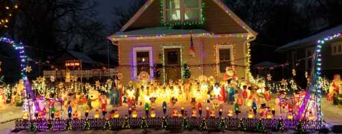 A festive house decorated with colorful Christmas lights and various holiday figures in a snowy yard.