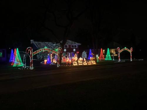 A festive display of colorful holiday lights featuring trees, candy canes, and decorations in a dark setting.