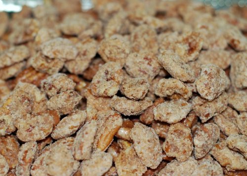 A close-up of a pile of sweet, crunchy coated nuts, showcasing their textured, sugary surface.