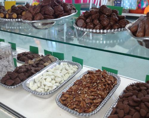A display of assorted chocolates and candies in silver trays, including nuts and coated treats.