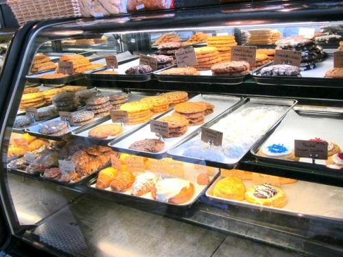 A display case filled with various cookies and pastries, each labeled with small signs.