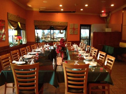 A cozy restaurant interior with two long tables set for dining, decorated with flowers and candles.