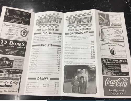 A menu featuring breakfast and lunch options, including plates, biscuits, sandwiches, and drinks, with prices listed.