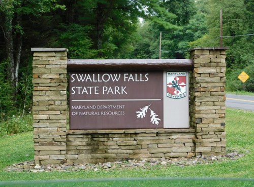 Sign for Swallow Falls State Park, featuring the Maryland Department of Natural Resources logo and surrounded by greenery.