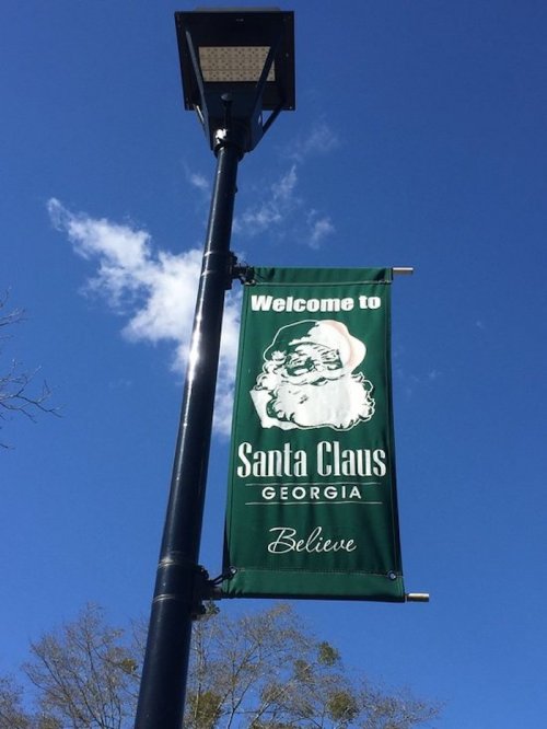 Green banner hanging from a lamp post reads "Welcome to Santa Claus, Georgia" with an illustration of Santa.