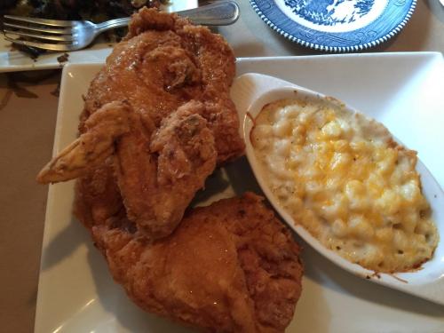 A plate featuring two pieces of fried chicken and a side of creamy macaroni and cheese.