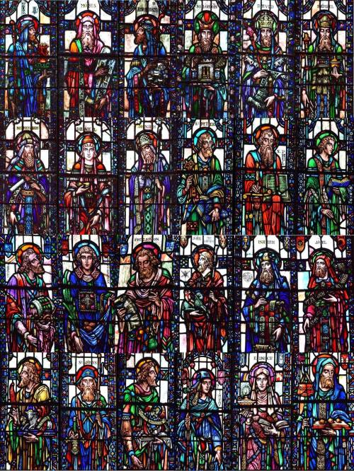 A colorful stained glass window featuring various saints and biblical figures in intricate designs.