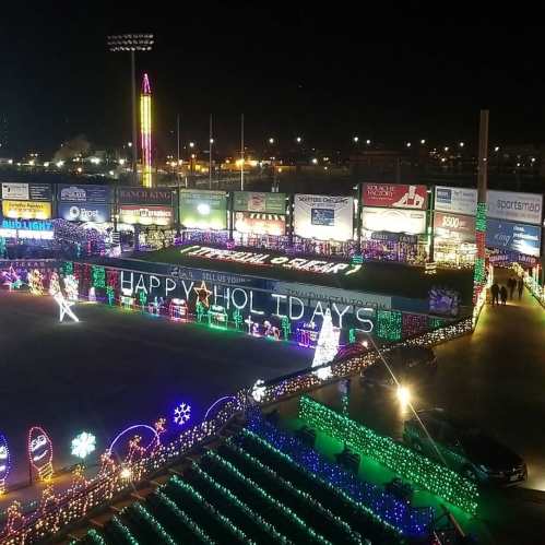 A brightly lit stadium decorated with colorful holiday lights and festive displays, creating a cheerful atmosphere.