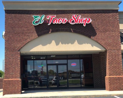 Exterior of El Taco Shop featuring a red and green sign, large windows, and an "Open" sign.