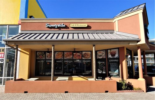 Exterior of Sunnyside Café & Restaurant, featuring a colorful building with menu displays and outdoor seating.