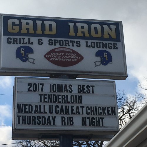Sign for Grid Iron Grill & Sports Lounge promoting 2017 Iowa's Best Tenderloin, all-you-can-eat chicken, and rib night.