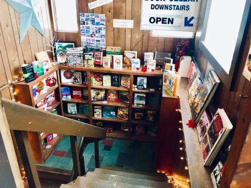 A cozy staircase leading to a book cellar, lined with shelves of books and festive decorations.