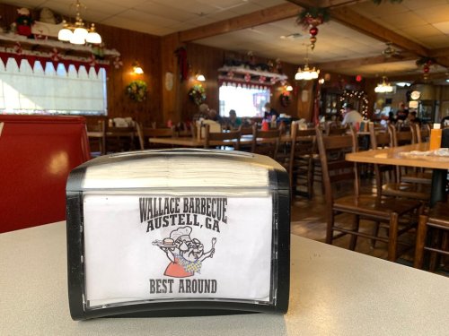 A menu holder on a table at Wallace Barbecue in Austell, GA, featuring the text "Best Around" and a graphic of a chef.