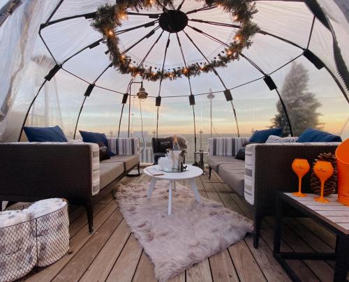 Cozy dome seating area with plush sofas, a coffee table, and festive decor, overlooking a scenic sunset.