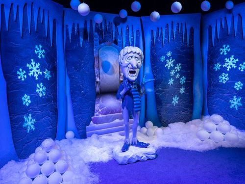 A whimsical ice-themed scene featuring a snowman statue surrounded by snowballs and icy decorations.