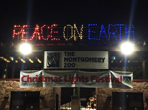 Entrance to the Montgomery Zoo, decorated with lights reading "Peace on Earth" and a banner for the Christmas Lights Festival.