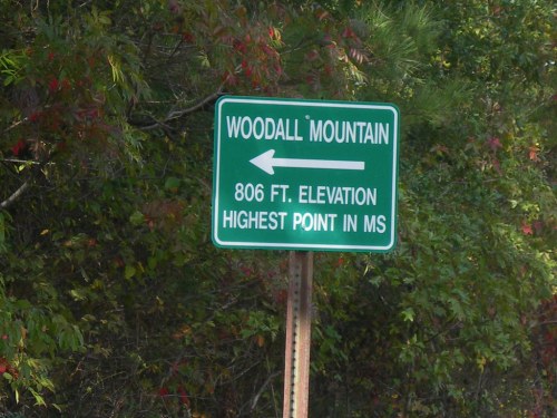 Sign for Woodall Mountain, indicating 806 ft elevation and marking the highest point in Mississippi. Arrow points left.