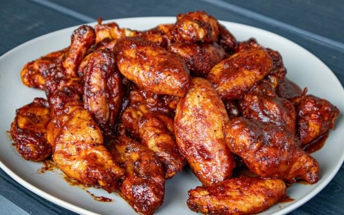 A plate of spicy, glazed chicken wings piled high, showcasing a rich, dark sauce.