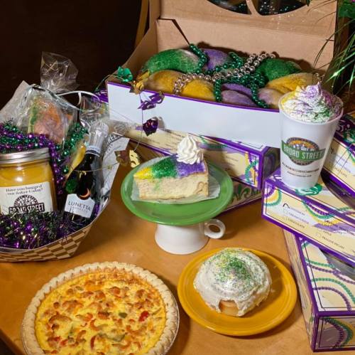 A festive display of Mardi Gras treats, including cakes, pastries, and colorful decorations.