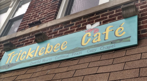 Sign for Tricklebee Café featuring cheerful hearts and cozy chapel themes, with a whimsical design.