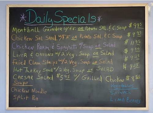 Chalkboard menu listing daily specials, including meatball grinder, chicken salad, liver and onions, and various soups.