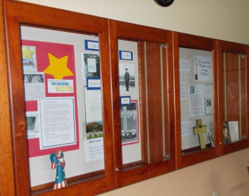 Display case featuring documents, photos, and memorabilia related to military service and community history.