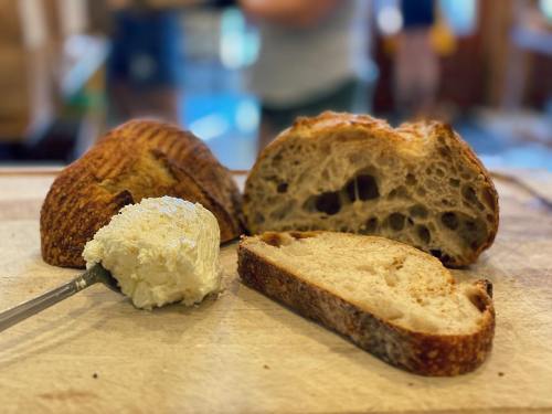 A wooden board with slices of crusty bread and a dollop of creamy spread.