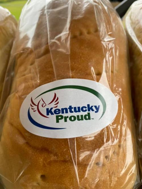 A loaf of bread wrapped in plastic with a "Kentucky Proud" sticker on it.