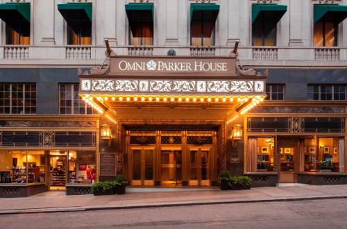 The illuminated entrance of the Omni Parker House hotel, featuring elegant architecture and marquee lights.