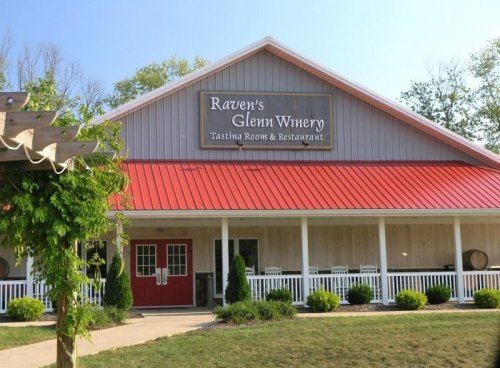 Exterior of Raven's Glenn Winery featuring a red roof, wooden siding, and a sign for the tasting room and restaurant.