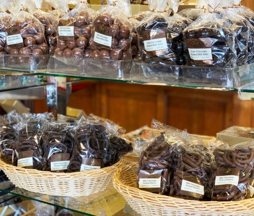 A display of assorted chocolates in clear bags, including dark chocolate truffles and milk chocolate treats.
