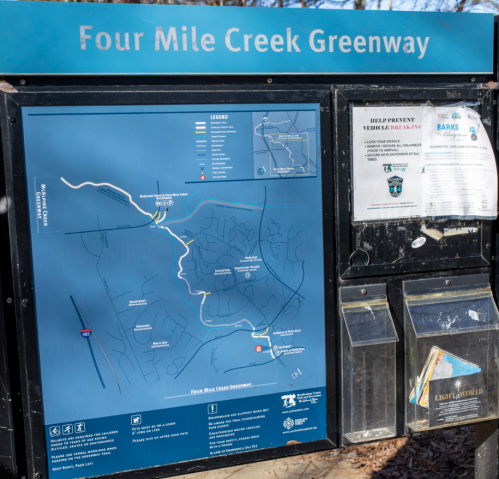 Map of Four Mile Creek Greenway, showing trails and nearby areas, with informational flyers attached.