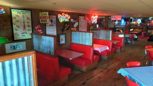 A cozy diner interior with red booths, wooden accents, and vintage signs on the walls, creating a nostalgic atmosphere.